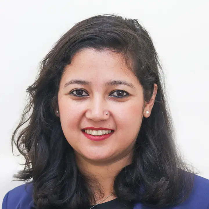 headshot of a smiling Nepali woman with long black hair