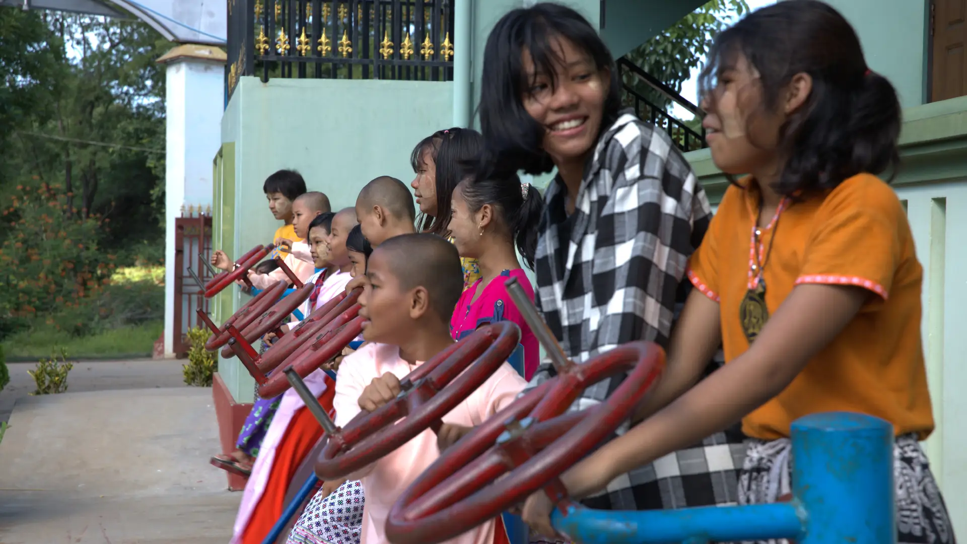 An informal photo of Burmese young people/children chatting and smiling