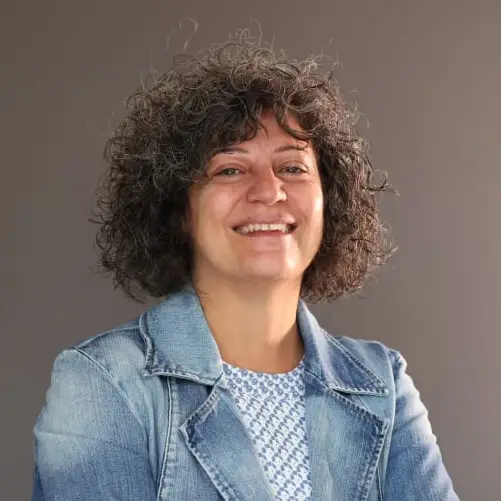 Headshot of a smiling Lebanese woman with chin-length curly dark hair