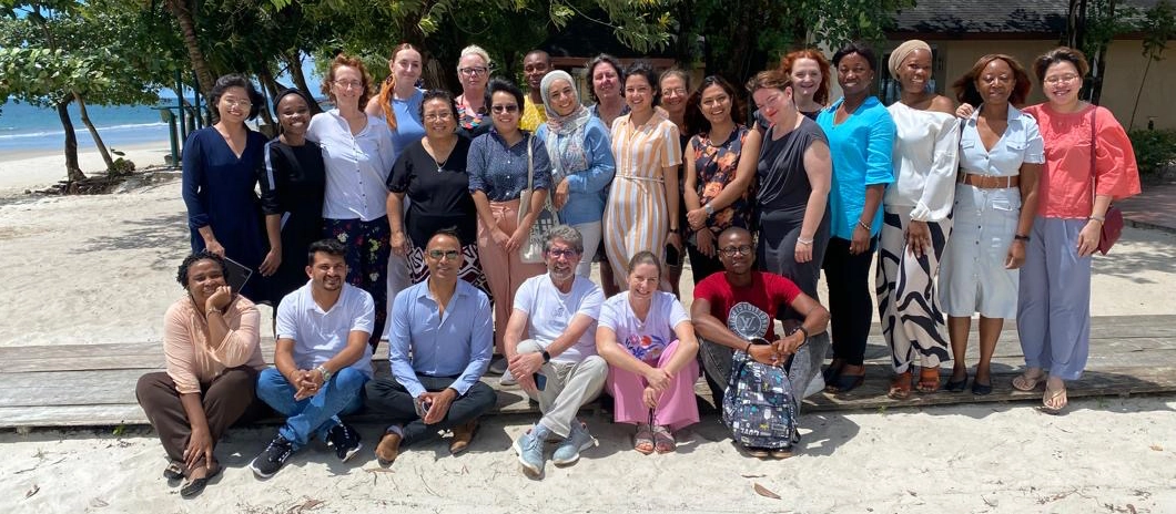 A group of smiling men and women on a beach