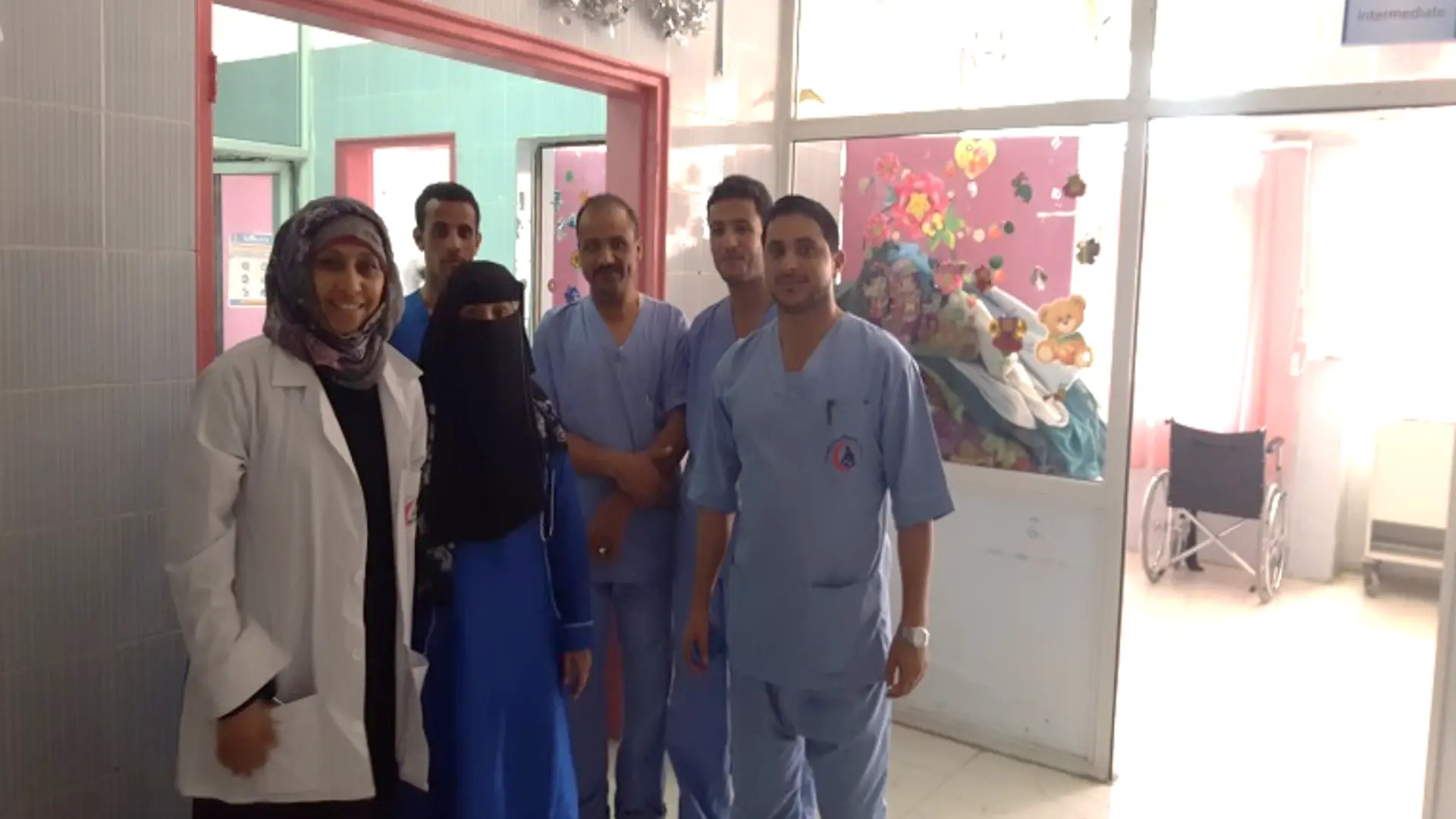Six Yemeni medics in a children's hospital. They stand smiling at the camera
