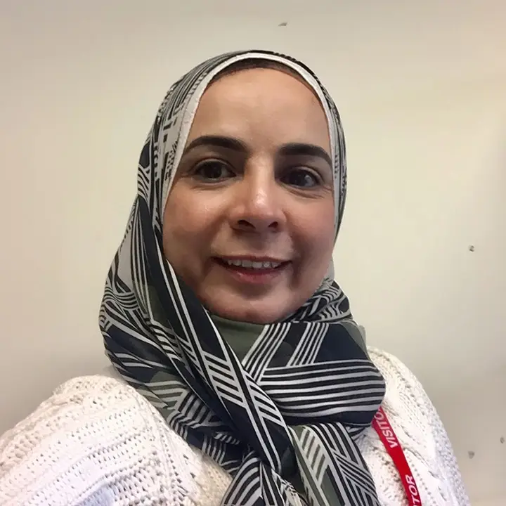 Headshot of a smiling Egyptian woman wearing a headscarf